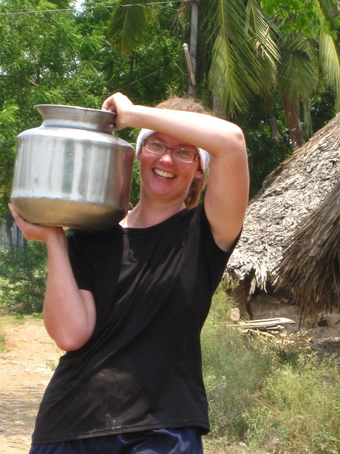 carrying the hand pumped water to mix the cement, church building, India