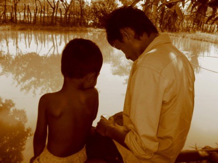 Sopheap with a boy from his family near their pond