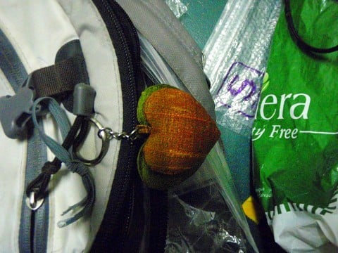 The green heart is bigger than the orange one.  The little orange heart is inside the green one.  