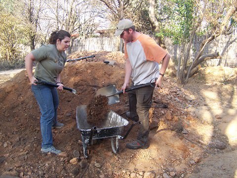 Cricket and Mark shoveling dirt to place in front of the girls' house