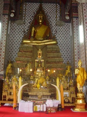 An alter where buddhists worship and pray. Notice the pile of gifts laid at the bottom of the alter.
